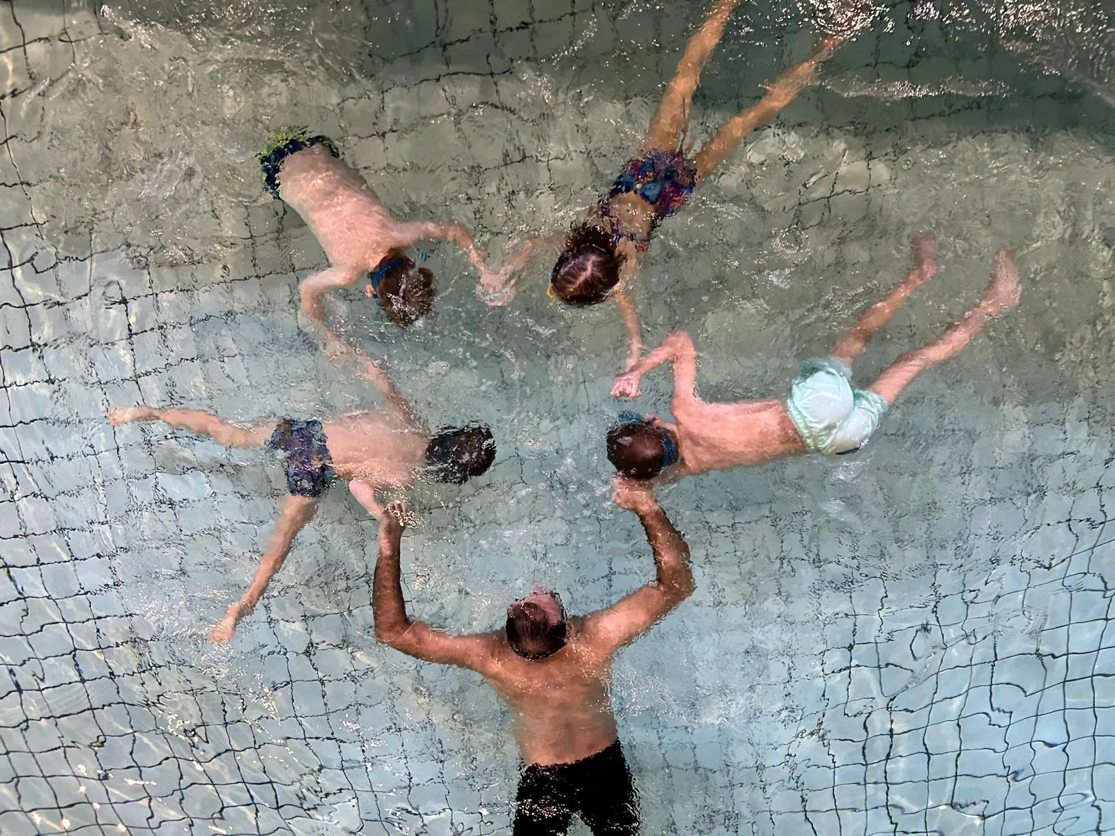 Children swimming lesson in pool with instructor